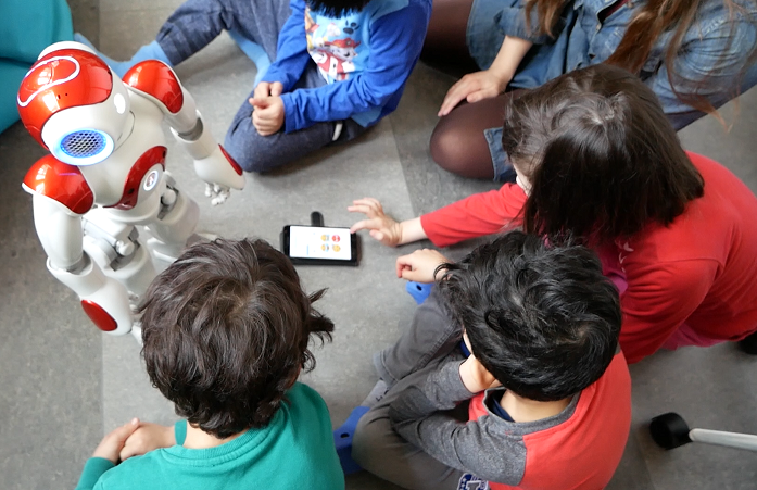 Children and a classroom robot during a learning session.